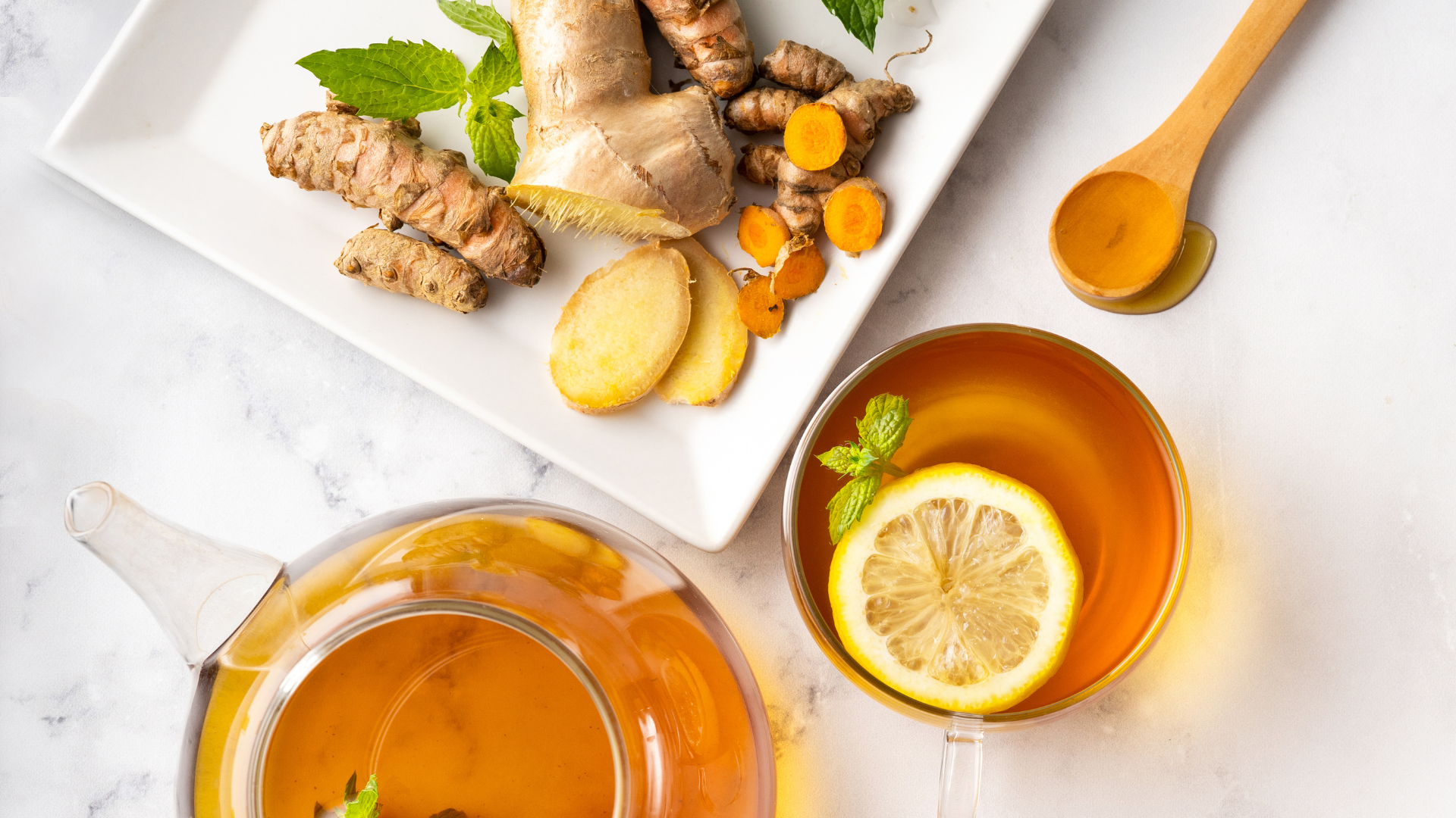 overview of glass tea pot with lemon, turmeric, and ginger