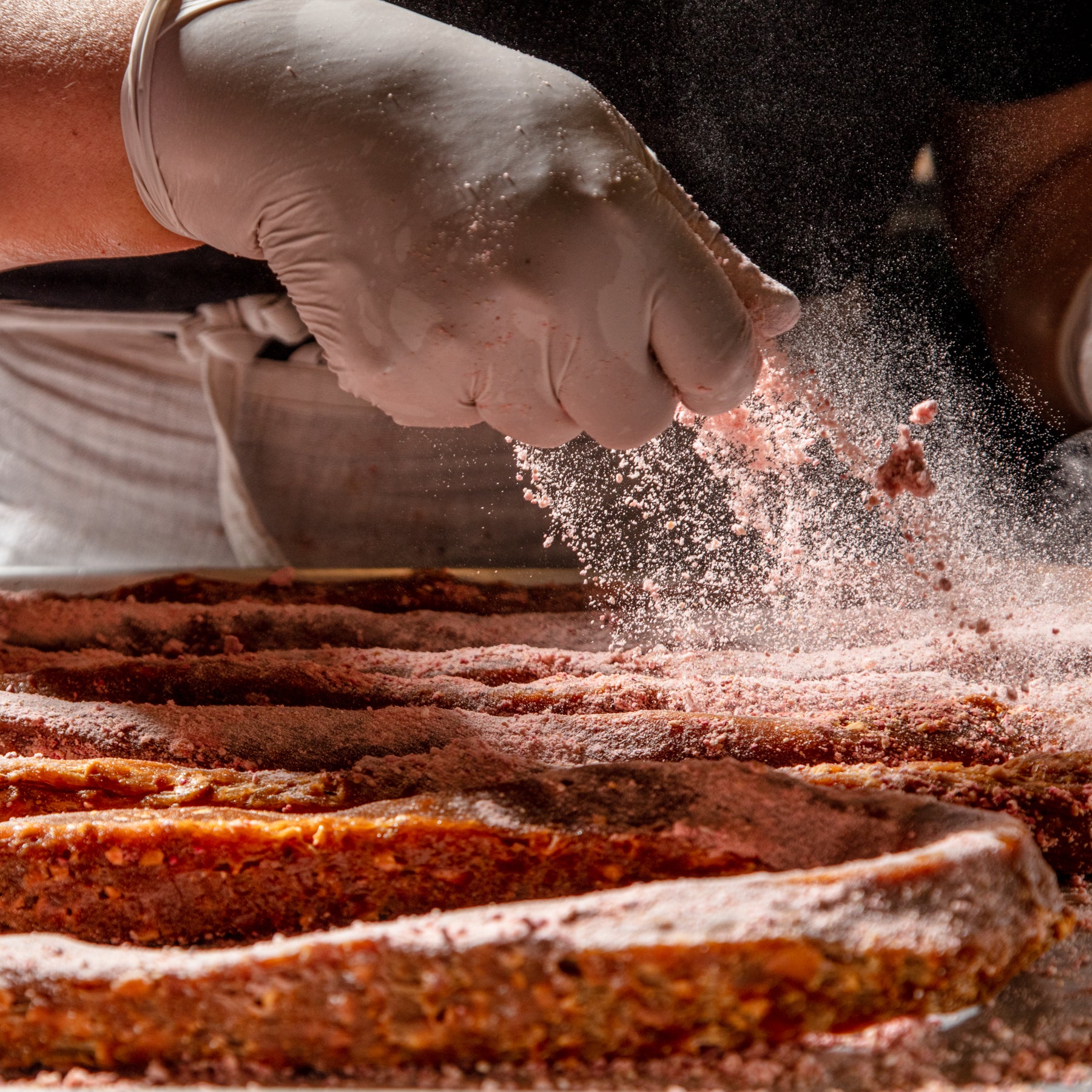 Photo of Little Apple Treats Apple Cider Caramels being dusted with Pink Pearl apple dust