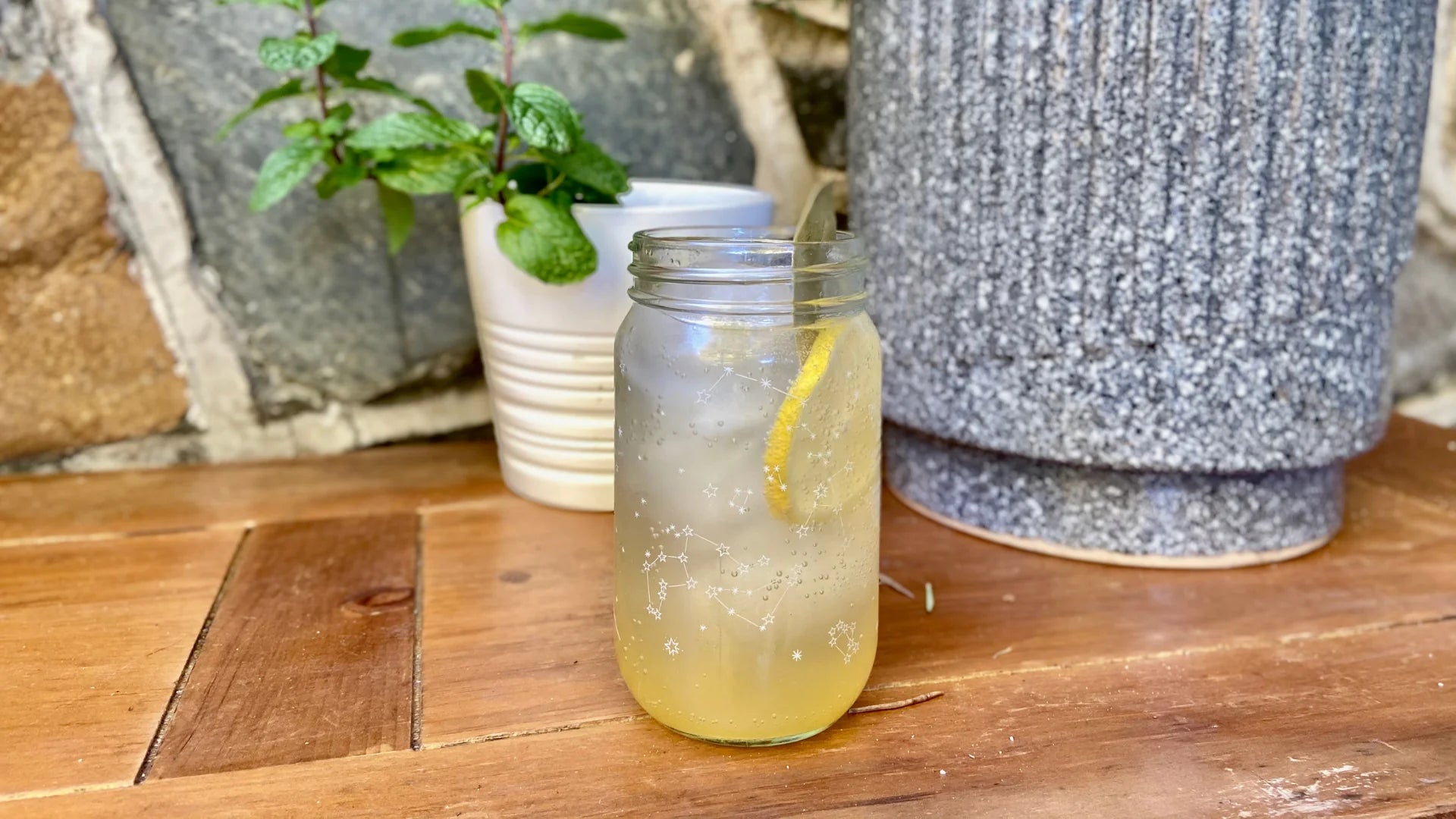 a bubbly mocktail garnished with lemon and bay leaf