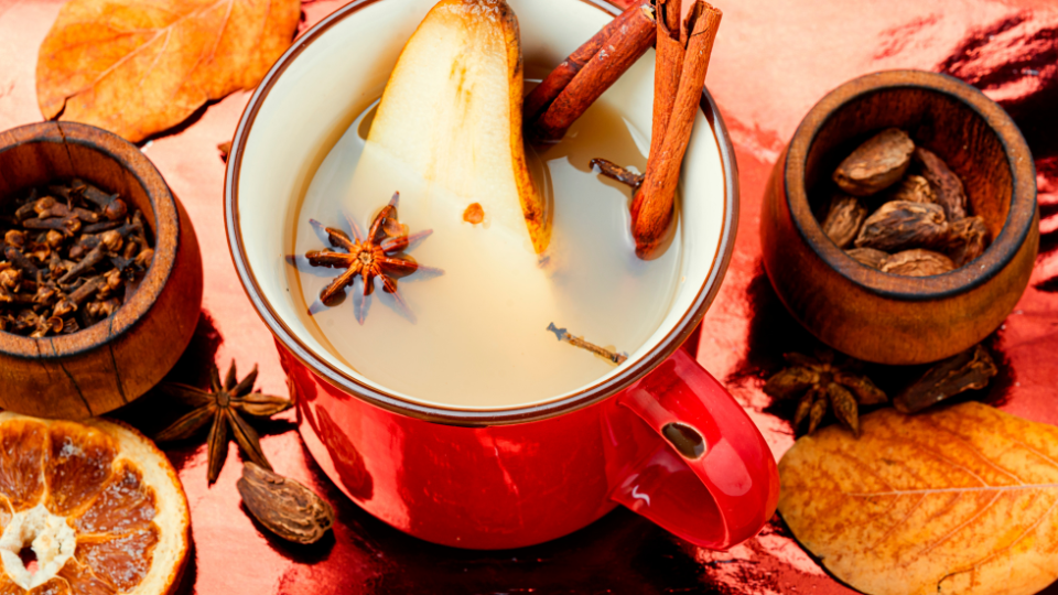 a red mug with pear, cinnamon, and winter wassail 